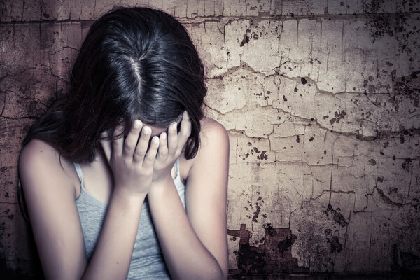 Teenage girl crying sitting on the floor