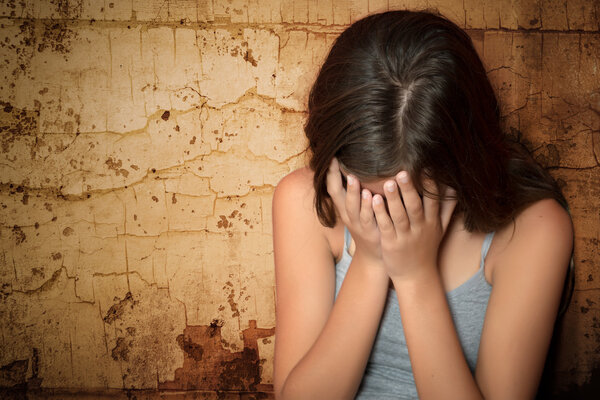 Teenage girl crying sitting on the floor