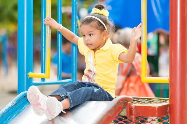 Fille en utilisant la glissière à aire de jeux — Photo