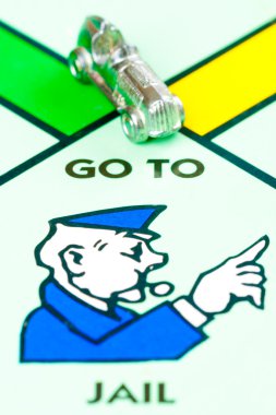 Car token next to GO TO JAIL in a Monopoly game clipart