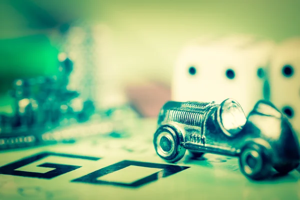 Tokens and dice next to the GO in a Monopoly board — Stock Photo, Image