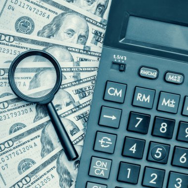 Bir hesap makinesi ve Büyüteç ile para