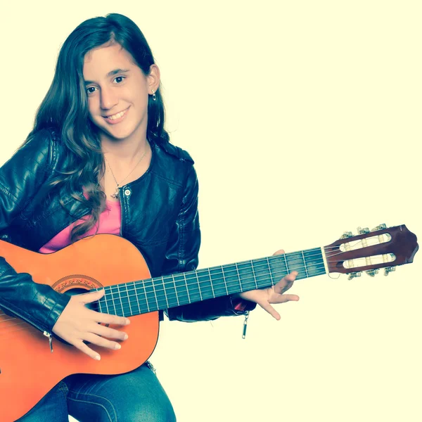 Trendiga spansktalande tonårig flicka spelar en akustisk gitarr — Stockfoto
