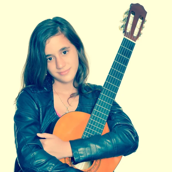 Beautiful hispanic teenage girl hugging her acoustic guitar — Stock Photo, Image