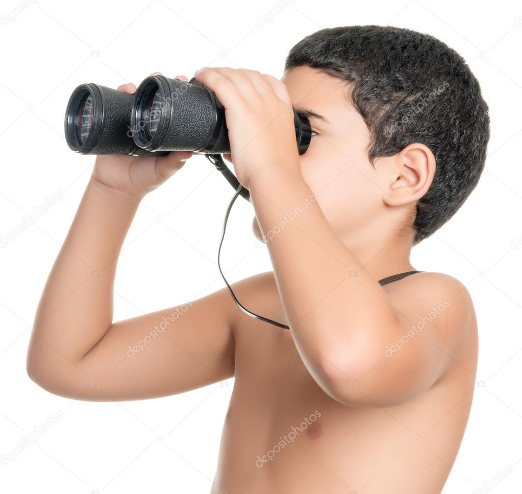 Shirtless hispanic boy looking through binoculars