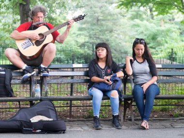 Street performer singing John Lennon songs at Strawberry Fields in Central Park, New York