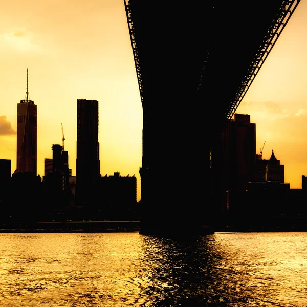 Silueta del horizonte del centro de Manhattan y el puente de Manhattan al atardecer — Foto de Stock