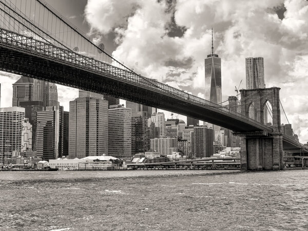 Black and white view of the Brooklyn Bridge and the downtown Manhattan skyline in New York City