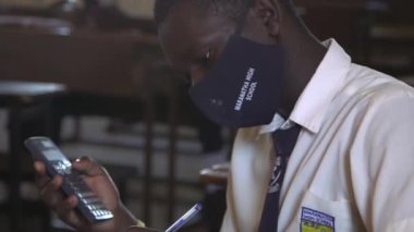 Doğu Afrika 'nın başkenti Kampala' daki Maranatha Lisesi 'nde Kasım 2020' de meydana gelen koronavirüs salgını yüzünden kimliği belirsiz öğrenci koruyucu maske takıyor.
