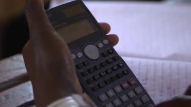 Doğu Afrika 'nın başkenti Kampala' daki Maranatha Lisesi 'nde hesap makinesi kullanan tanımlanamayan öğrenci Kasım 2020