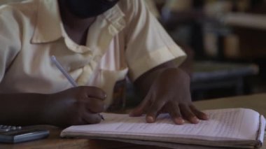 Doğu Afrika 'nın başkenti Kampala' daki Maranatha Lisesi 'nde Kasım 2020' de meydana gelen koronavirüs salgını yüzünden kimliği belirsiz öğrenci koruyucu maske takıyor.