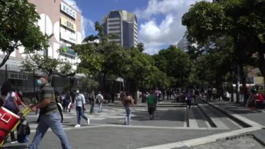 Venezuela 'nın başkenti Chacaito, Caracas' taki Plaza Brion 'da 19 Aralık 2020' de meydana gelen COVID-19 virüsü nedeniyle çoğu koruyucu maskeli, kimliği belirsiz kişiler