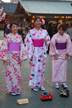TOKYO, JAPONAN - 23 Mart 2014: Tokyo 'daki Senso-ji Tapınağı' nda Kiraz Çiçeği (Sakura) adlı geleneksel bir elbise giyen genç Japon kadınları.