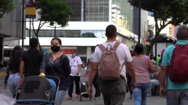 Venezuela 'nın başkenti Chacaito, Caracas' taki Plaza Brion 'da 19 Aralık 2020' de meydana gelen COVID-19 virüsü nedeniyle çoğu koruyucu maskeli, kimliği belirsiz kişiler