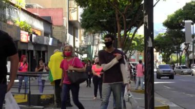 Venezuela 'nın başkenti Chacaito, Caracas' taki Plaza Brion 'da 19 Aralık 2020' de meydana gelen COVID-19 virüsü nedeniyle çoğu koruyucu maskeli, kimliği belirsiz kişiler