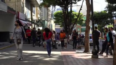 Venezuela 'nın başkenti Chacaito, Caracas' taki Plaza Brion 'da 19 Aralık 2020' de meydana gelen COVID-19 virüsü nedeniyle çoğu koruyucu maskeli, kimliği belirsiz kişiler