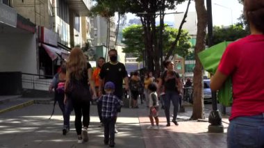 Venezuela 'nın başkenti Chacaito, Caracas' taki Plaza Brion 'da 19 Aralık 2020' de meydana gelen COVID-19 virüsü nedeniyle çoğu koruyucu maskeli, kimliği belirsiz kişiler
