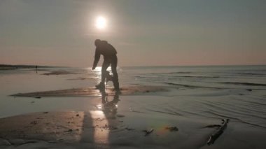 Bir köpek bir gün batımı denizde kızla