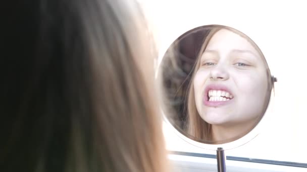 Modèle de beauté adolescente regardant dans le miroir et vérifier sa peau, l'application de maquillage. 4K — Video