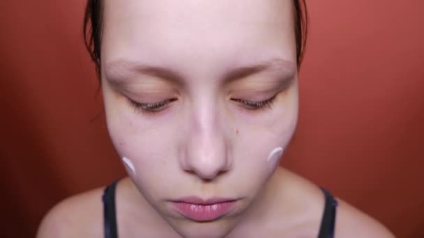 Ομορφιά έφηβος κορίτσι την κρέμα στο πρόσωπό της, 4k — Αρχείο Βίντεο