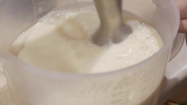 Flüssige Lebensmittel in einer Schüssel mit einem Mixer mischen. 4k — Stockvideo