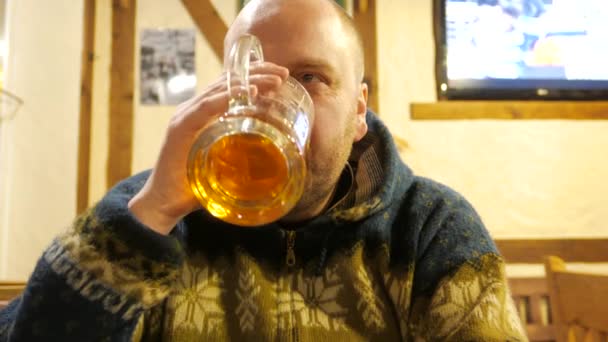 Un homme qui boit de la bière dans un bar et s'amuse. 4K UHD — Video