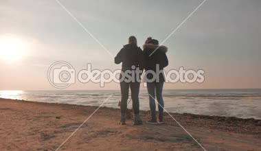 Bir köpek bir gün batımı denizde 4k ile iki kız