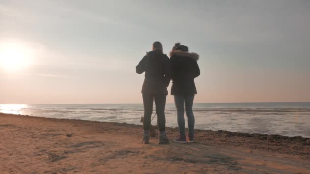 Két lányok egy kutyus, naplemente tengeren, 4k — Stock videók