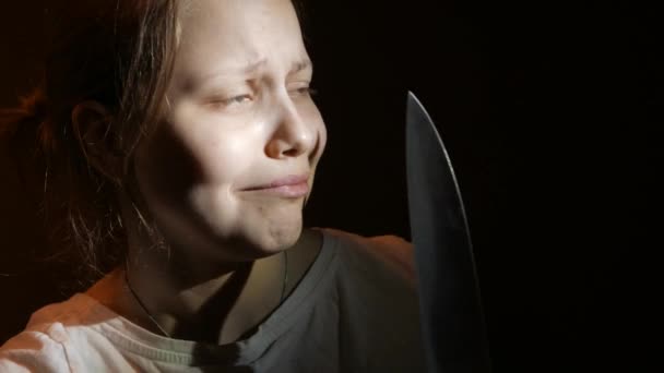 Chica adolescente con un cuchillo grande, película de terror escena oscura, 4K UHD — Vídeo de stock