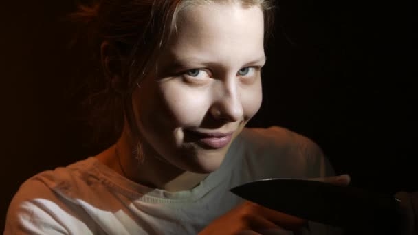 Dospívající dívka s velkým nožem a démonické úsměvem, horor film temné scéně, 4k Uhd