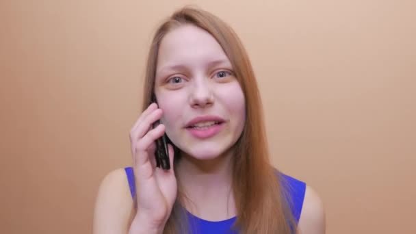 Ein junges und sehr emotionales Teenie-Mädchen kommuniziert per Telefon. 4k uhd. — Stockvideo