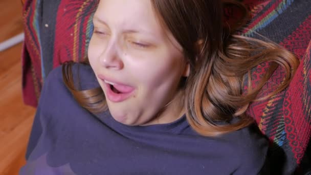 Крупним планом нещасна дівчинка-підліток, що сидить і позіхає. 4K UHD . — стокове відео