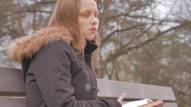Genç kız bir parkta bir kitap okuma. 4k Uhd