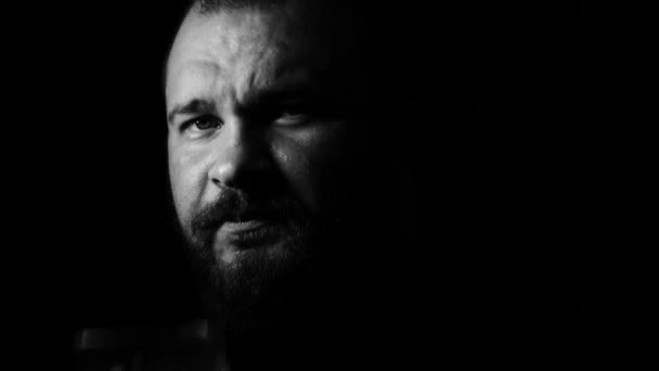 Portrait video of a tough bearded tattoed man with a glass of bear. Contrasty black and white. 4K UHD — Stock Video