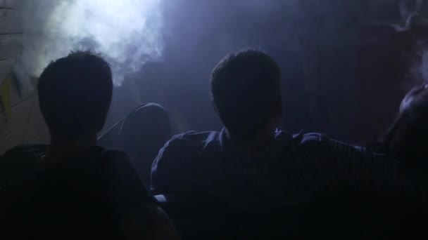 Um grupo de pessoas vaporizando, inalando e exalando grandes nuvens de fumaça e se divertindo juntos. Companhia de bons amigos. 4K UHD . — Vídeo de Stock