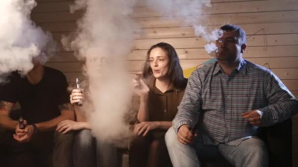 Bir grup insanlar vaping, teneffüs edilmesi ve büyük bulutlar duman exhaling ve birlikte eğlenmek. İyi arkadaş şirket. 4k Uhd. — Stok video