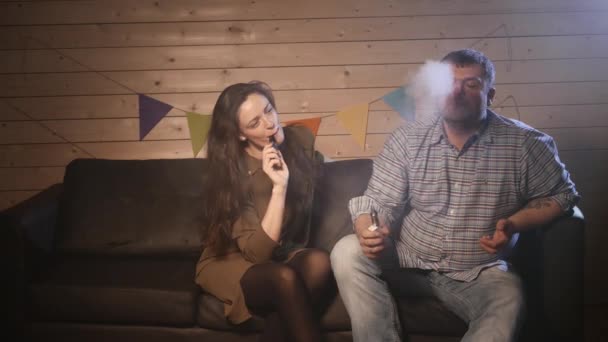 Un couple vaporisant, inhalant et expirant de grands nuages de fumée et s'amusant ensemble. Compagnie de bons amis. 4K UHD . — Video