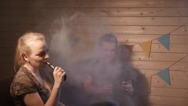 Un grup de oameni care vapează, inhalează și expiră nori mari de fum și se distrează împreună. Companie de prieteni buni. 4K UHD . — Videoclip de stoc