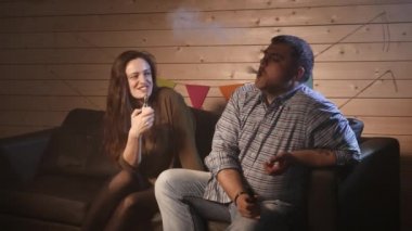 Bir çift vaping, teneffüs edilmesi ve büyük bulutlar duman exhaling ve birlikte eğlenmek. İyi arkadaş şirket. 4k Uhd.