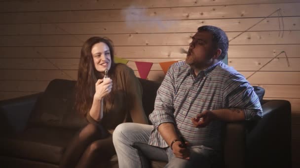 Una coppia che vaporizza, inala ed espira grandi nuvole di fumo e si diverte insieme. Compagnia di buoni amici. 4K UHD . — Video Stock