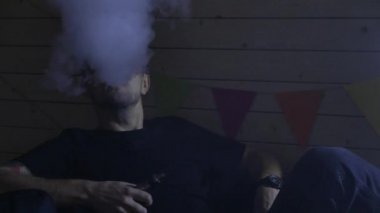 Bir grup insanlar vaping, teneffüs edilmesi ve büyük bulutlar duman exhaling ve birlikte eğlenmek. İyi arkadaş şirket. 4k Uhd.