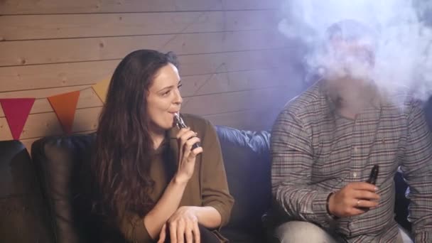 Un couple vaporisant, inhalant et expirant de grands nuages de fumée et s'amusant ensemble. Compagnie de bons amis. 4K UHD . — Video