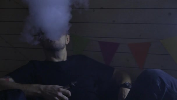 Um grupo de pessoas vaporizando, inalando e exalando grandes nuvens de fumaça e se divertindo juntos. Companhia de bons amigos. 4K UHD . — Vídeo de Stock