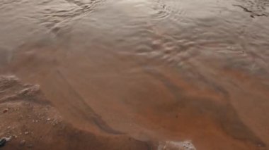 Soğuk kum, closeup akan su. 4k Uhd.