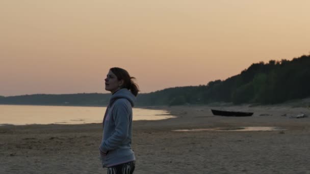 Dromerige jonge vrouw genieten van de zon op het strand. Noord Oostzee zeegezicht. 4k Uhd. — Stockvideo