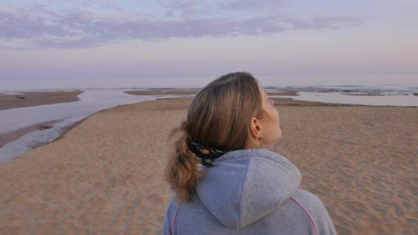 Jovencita soñadora disfrutando del sol en la playa. Paisaje marino del norte del Báltico. 4K UHD . — Vídeos de Stock