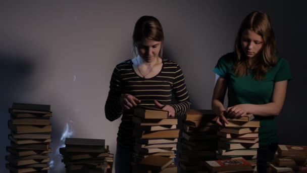 Zwei Mädchen, Mutter und ihre Teenager-Tochter oder zwei Schwestern lesen Bücher und haben Spaß mit Büchern. 4k uhd. — Stockvideo