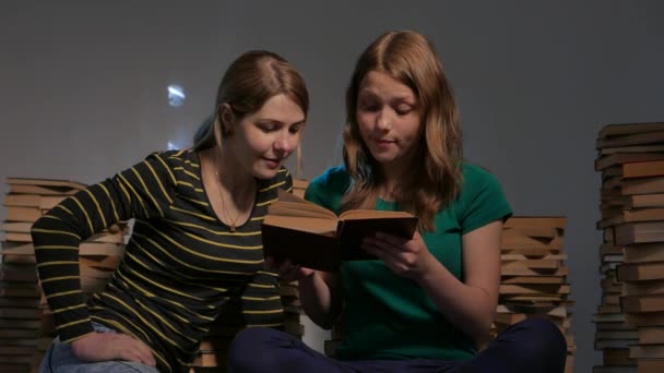 Dos niñas, su madre y su hija adolescente, o dos hermanas están leyendo libros y divirtiéndose con libros. 4K UHD . — Vídeos de Stock