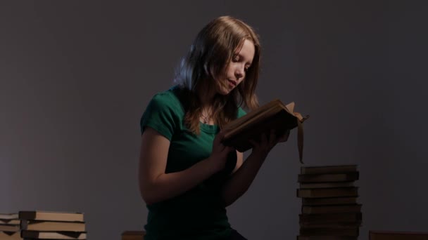 Κορίτσι περιβάλλεται από βιβλία και ανάγνωση. 4k Uhd. — Αρχείο Βίντεο