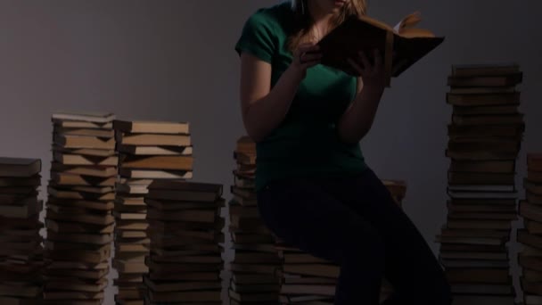 Chica adolescente está rodeada de libros y lectura. 4K UHD . — Vídeos de Stock